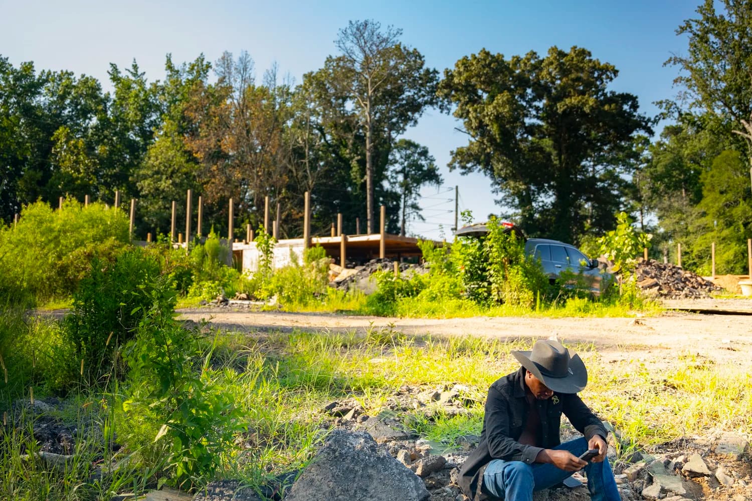 Brandon Fulton sits at his South Fulton property near an unfinished wooden structure.